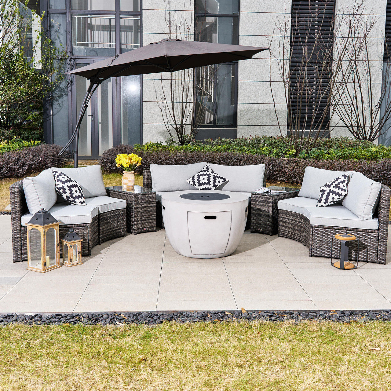 An outdoor set featuring an iron rattan sofa, glass table, and firepit.