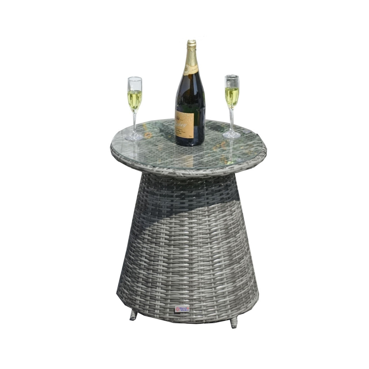 A round wicker bistro table with a glass top, featuring a bottle and two glasses on the table, indicating it is intended for outdoor use.